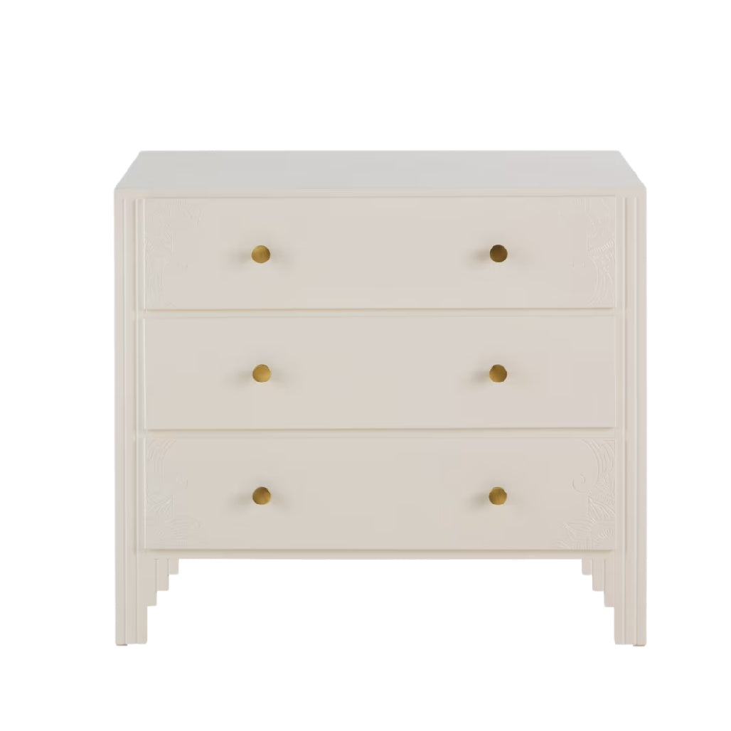 Commode élégante en blanc avec trois tiroirs et poignées dorées.